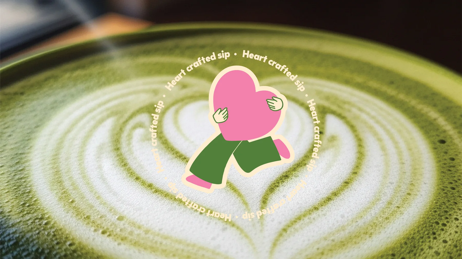 Matcha latte art with the Heart of Matcha mascot and the line Heart crafted sip. Cafe brand identity by LIRCLE